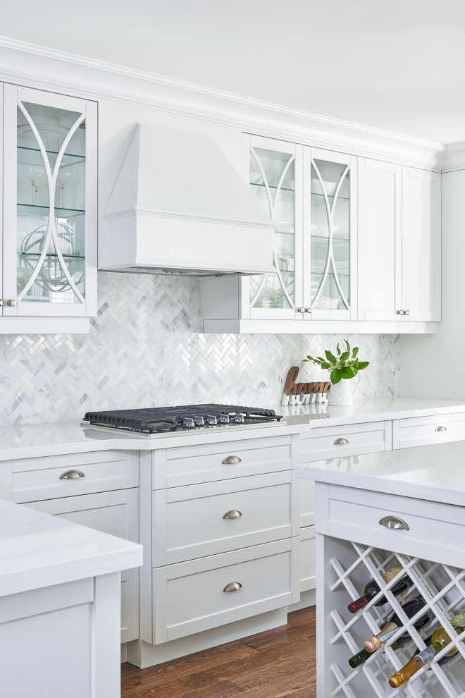 Mid-sized traditional galley eat-in kitchen in Toronto with an undermount sink, shaker cabinets, white cabinets, quartz benchtops, white splashback, marble splashback, stainless steel appliances, medium hardwood floors, with island, brown floor and white benchtop.