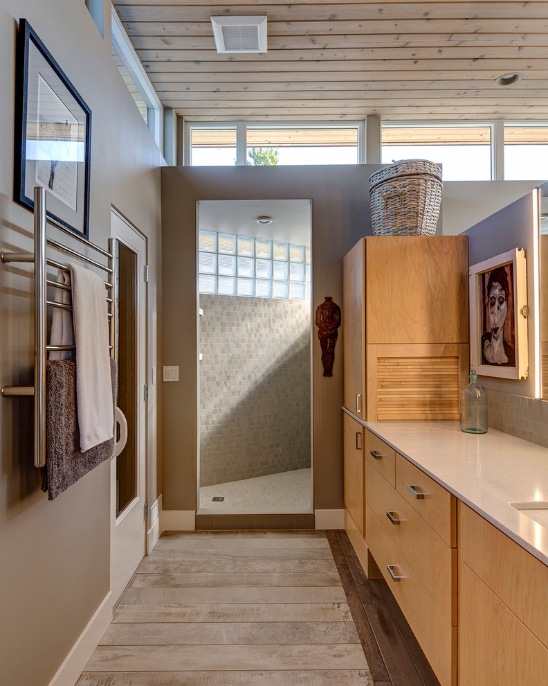 Inspiration for a mid-sized contemporary bathroom in Portland with an undermount sink, flat-panel cabinets, light wood cabinets, engineered quartz benchtops, beige tile, light hardwood floors and beige walls.