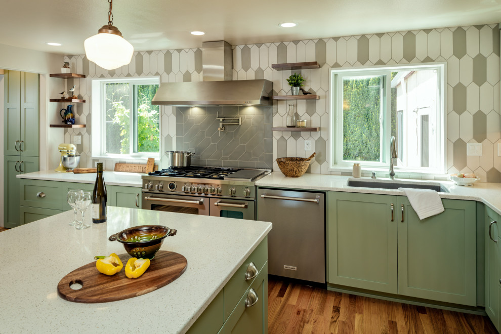 Example of a large transitional l-shaped medium tone wood floor eat-in kitchen design with an undermount sink, shaker cabinets, green cabinets, quartz countertops, gray backsplash, ceramic backsplash, stainless steel appliances, an island and white countertops