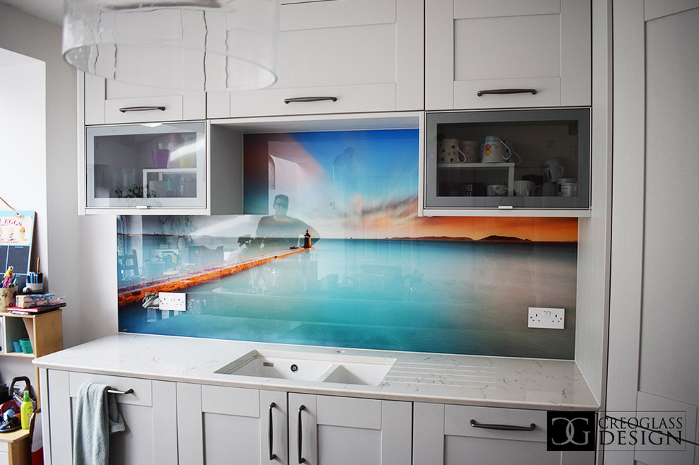 Design ideas for a large modern eat-in kitchen in Hertfordshire with white cabinets, multi-coloured splashback, glass sheet splashback, no island and turquoise benchtop.