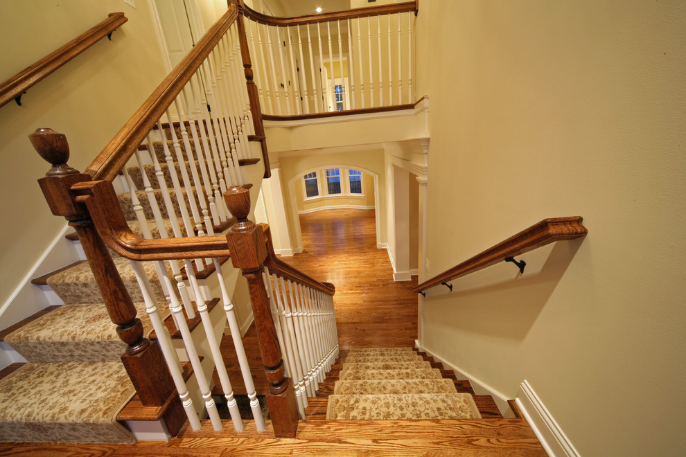 Large traditional wood straight staircase in Chicago with painted wood risers.