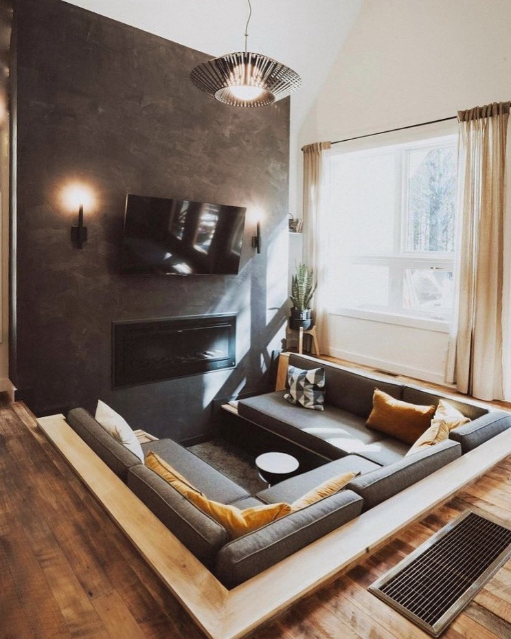 Kleines, Offenes Uriges Wohnzimmer mit weißer Wandfarbe, braunem Holzboden, TV-Wand und gewölbter Decke in Kolumbus