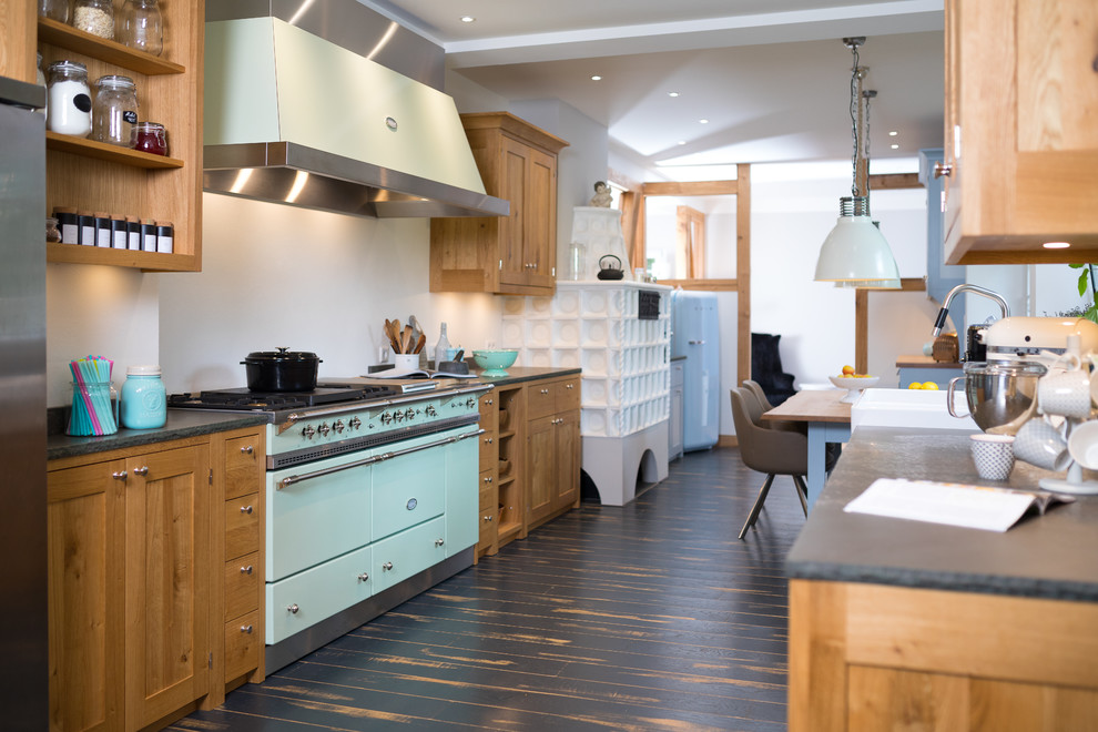 Inspiration for a large country galley eat-in kitchen in Cologne with a farmhouse sink, shaker cabinets, coloured appliances, dark hardwood floors, black floor, grey benchtop, medium wood cabinets, granite benchtops, white splashback, timber splashback and no island.