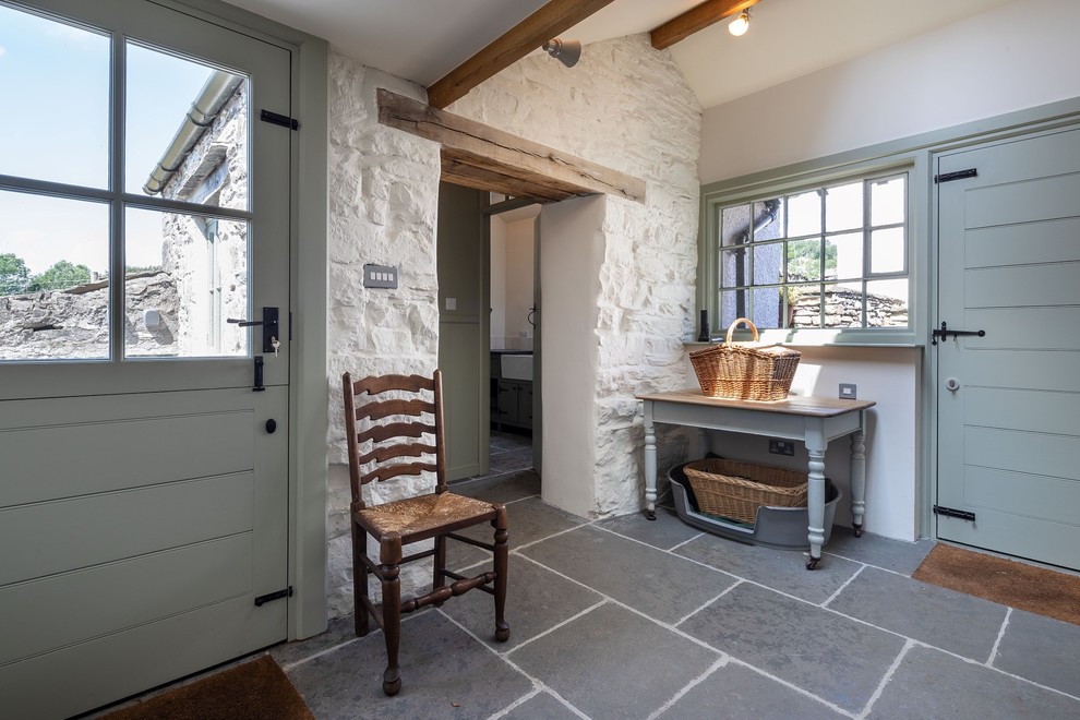 Inspiration for a large traditional galley dedicated laundry room in Other with a farmhouse sink, shaker cabinets, green cabinets, granite benchtops, white walls, slate floors, a concealed washer and dryer, blue floor and grey benchtop.