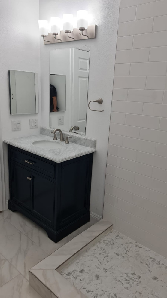 This is an example of a mid-sized master bathroom in Los Angeles with black cabinets, an open shower, a one-piece toilet, white tile, ceramic tile, white walls, cement tiles, a drop-in sink, quartzite benchtops, yellow floor, a hinged shower door, white benchtops, a single vanity and a freestanding vanity.