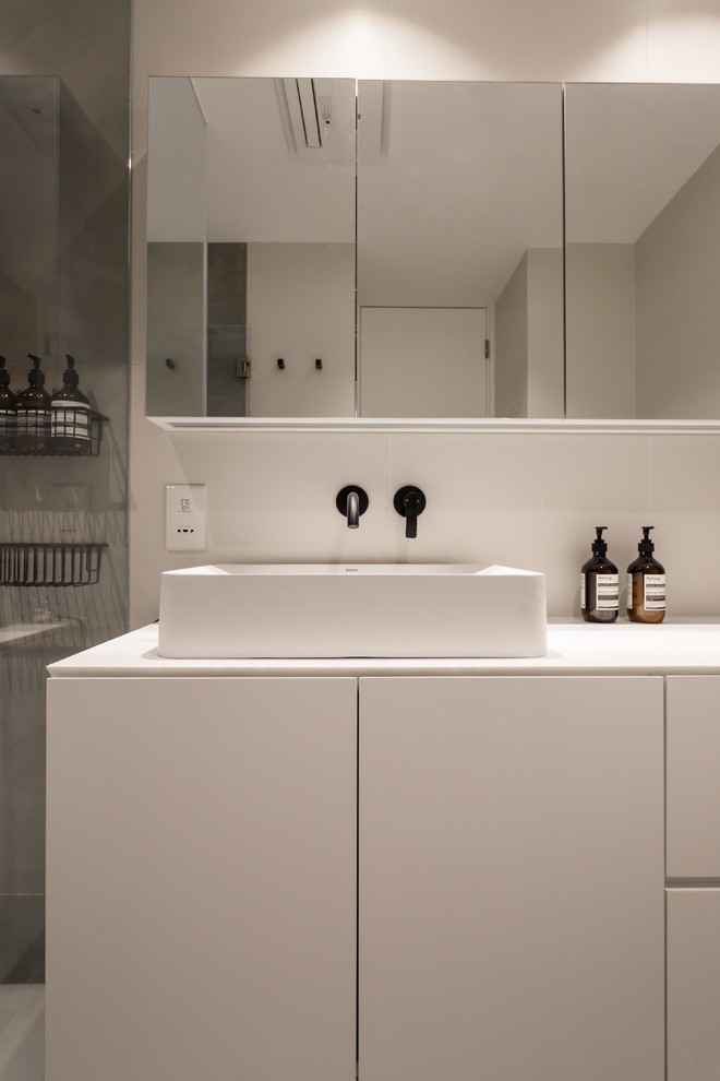 Photo of a small modern master bathroom in Hong Kong with a drop-in sink, white cabinets, marble benchtops, an alcove tub, a curbless shower, a bidet, gray tile, cement tile, white walls and ceramic floors.
