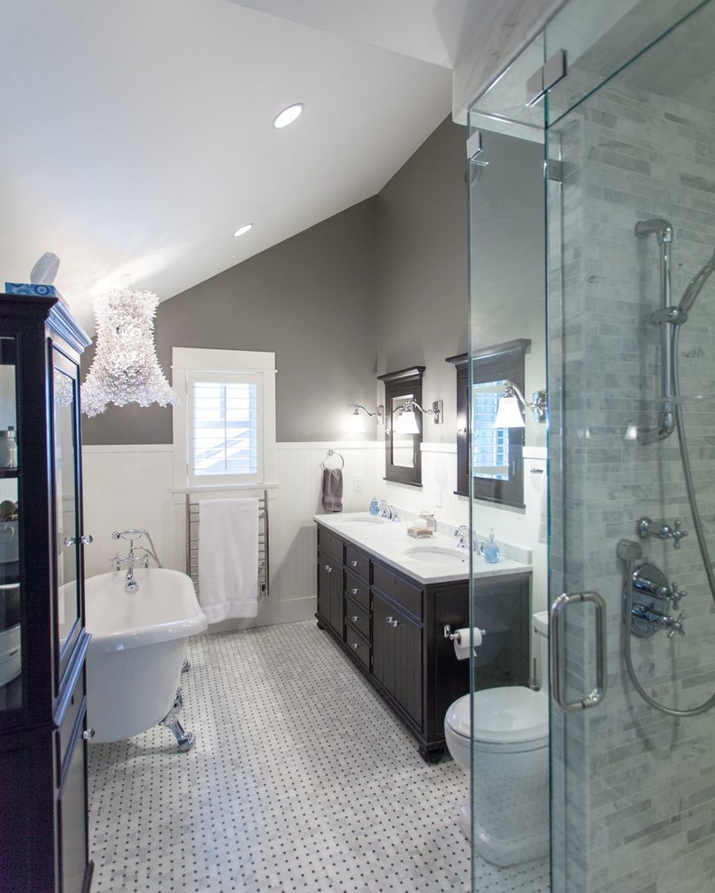 Photo of a large traditional master bathroom in Vancouver with an undermount sink, recessed-panel cabinets, granite benchtops, a claw-foot tub, a curbless shower, a two-piece toilet, grey walls, porcelain floors and dark wood cabinets.