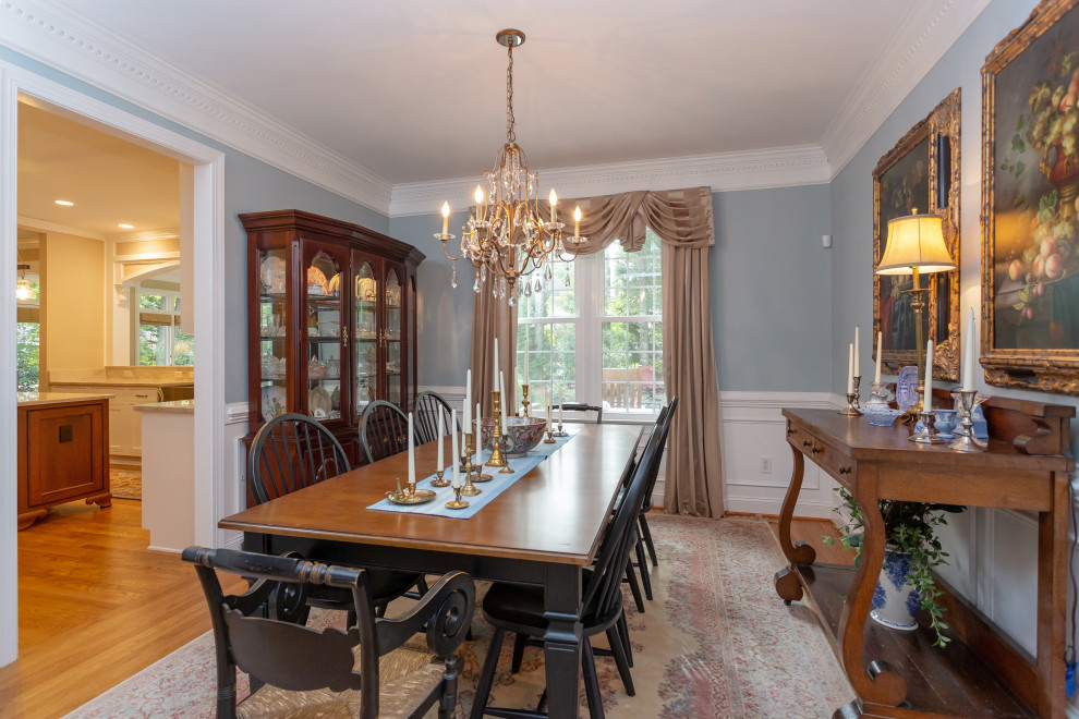 Mid-sized traditional separate dining room in Raleigh with blue walls, medium hardwood floors, no fireplace and brown floor.