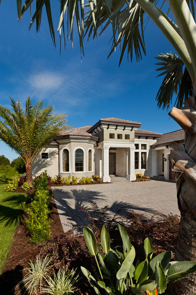 Photo of a mid-sized traditional one-storey stucco beige exterior in Tampa.
