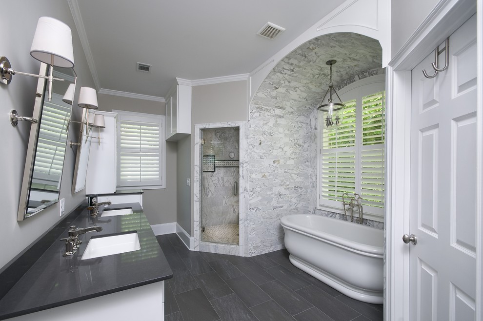 Photo of a large transitional master bathroom in Atlanta with an undermount sink, white cabinets, quartzite benchtops, a freestanding tub, a corner shower, white tile, beige walls and stone tile.