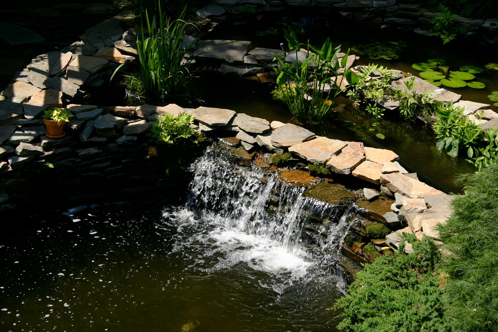 Geräumiger, Geometrischer Klassischer Garten im Sommer, hinter dem Haus mit Wasserspiel, direkter Sonneneinstrahlung und Natursteinplatten in Philadelphia