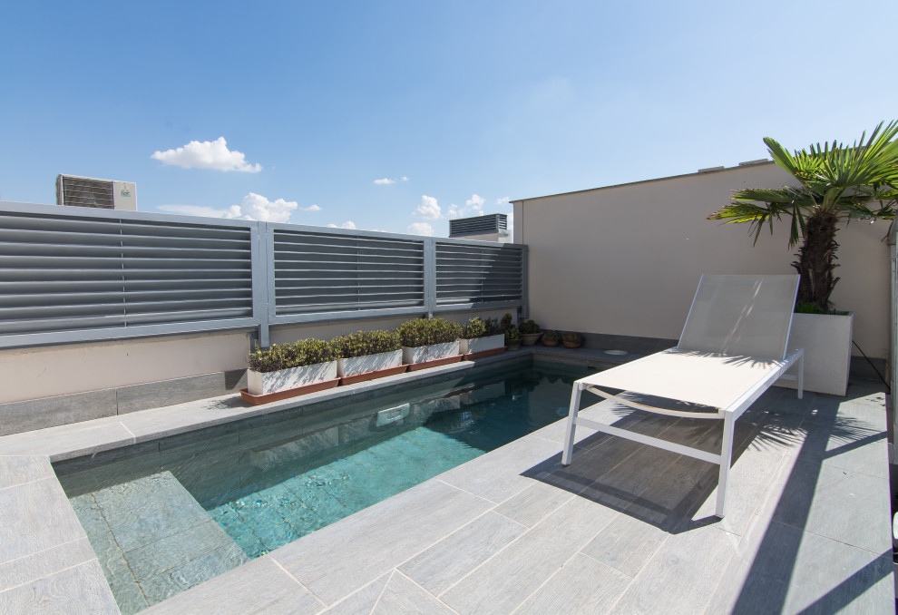 Design ideas for a mid-sized contemporary rooftop rectangular pool in Other with tile.