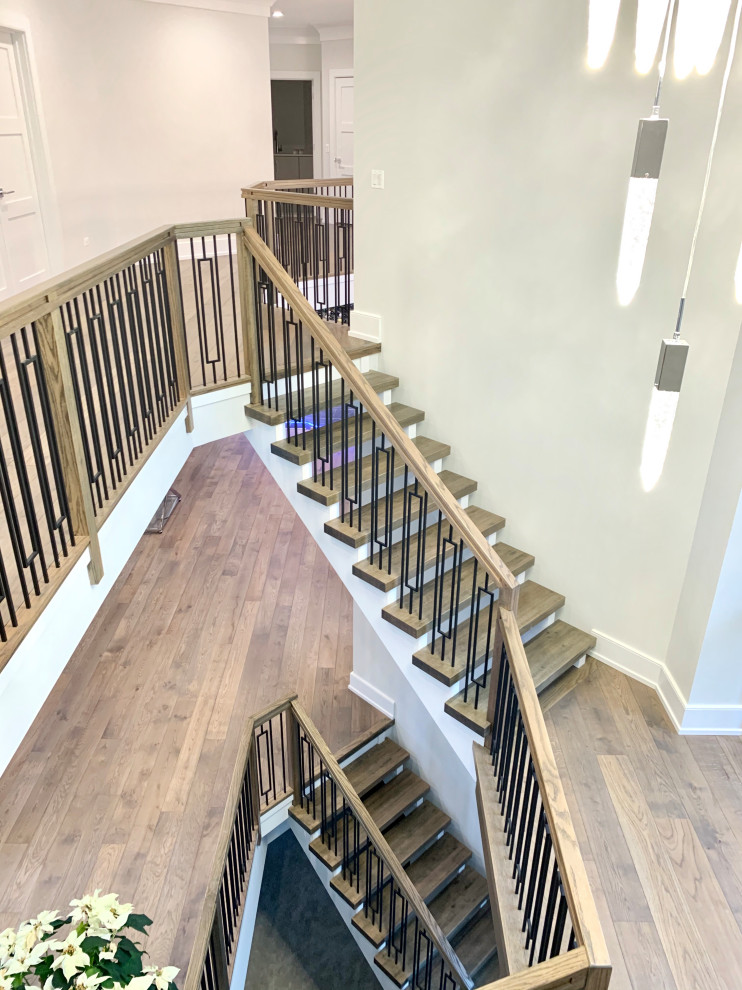 Large contemporary wood floating staircase in Chicago with wood railing.
