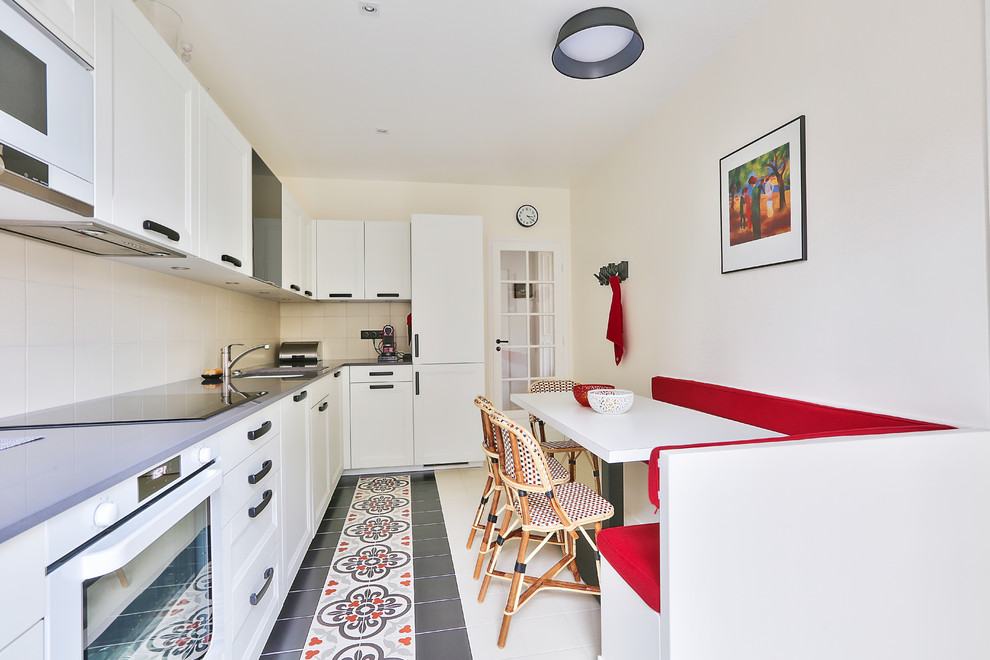 This is an example of a large transitional l-shaped separate kitchen in Paris with ceramic floors, an undermount sink, white cabinets, beige splashback, white appliances, beaded inset cabinets, quartzite benchtops, ceramic splashback, with island, red floor and grey benchtop.