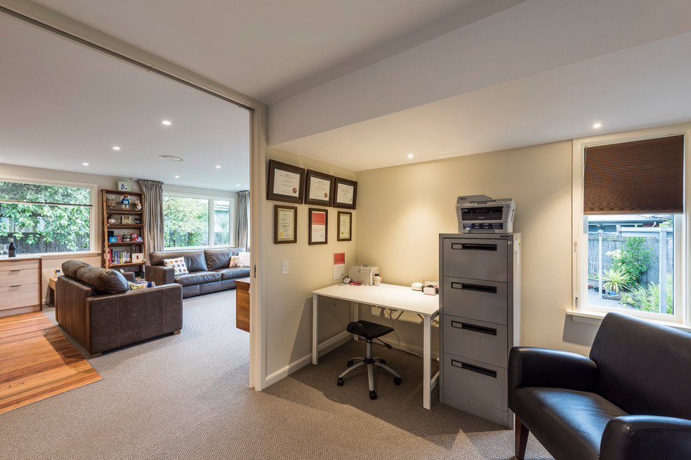 This is an example of a contemporary home office in Other with carpet.
