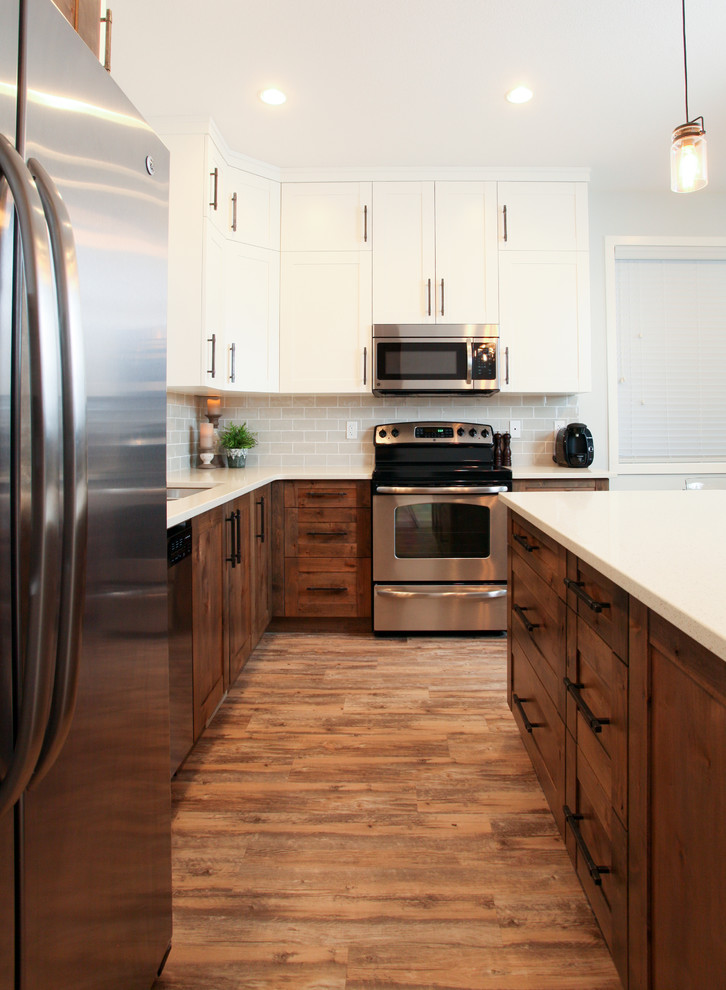 Inspiration for a large transitional l-shaped medium tone wood floor eat-in kitchen remodel in Calgary with shaker cabinets, an island, an undermount sink, dark wood cabinets, quartz countertops, gray backsplash, subway tile backsplash and stainless steel appliances