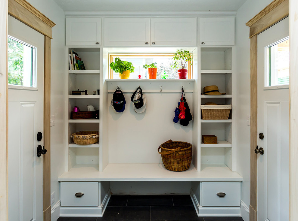 This is an example of a small traditional mudroom in Other with white walls, slate floors and a single front door.