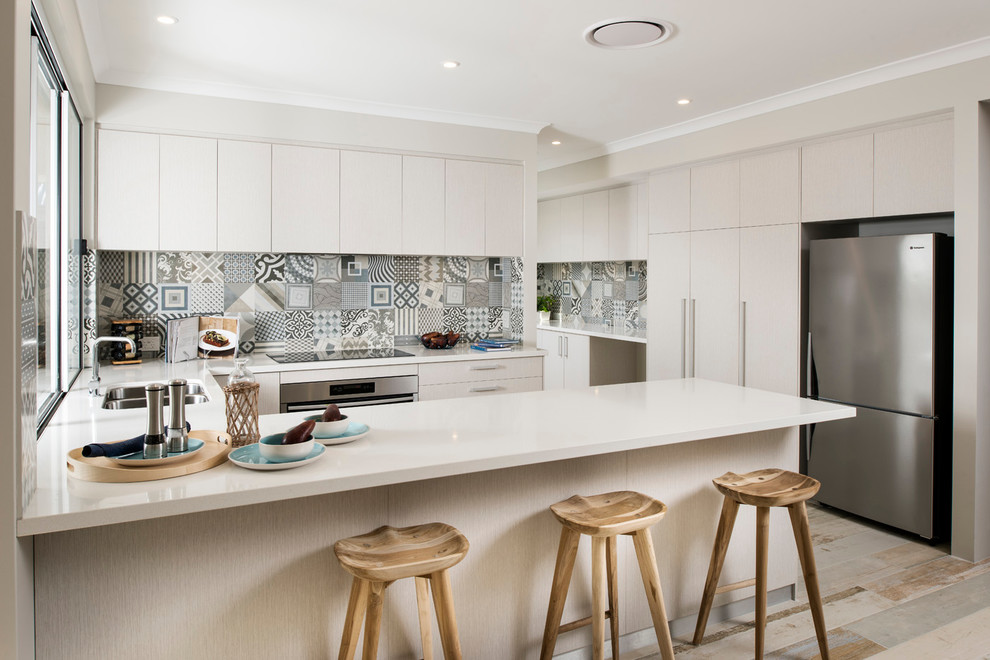 Large scandinavian u-shaped open plan kitchen in Perth with an undermount sink, flat-panel cabinets, multi-coloured splashback, ceramic splashback, stainless steel appliances, painted wood floors and white cabinets.