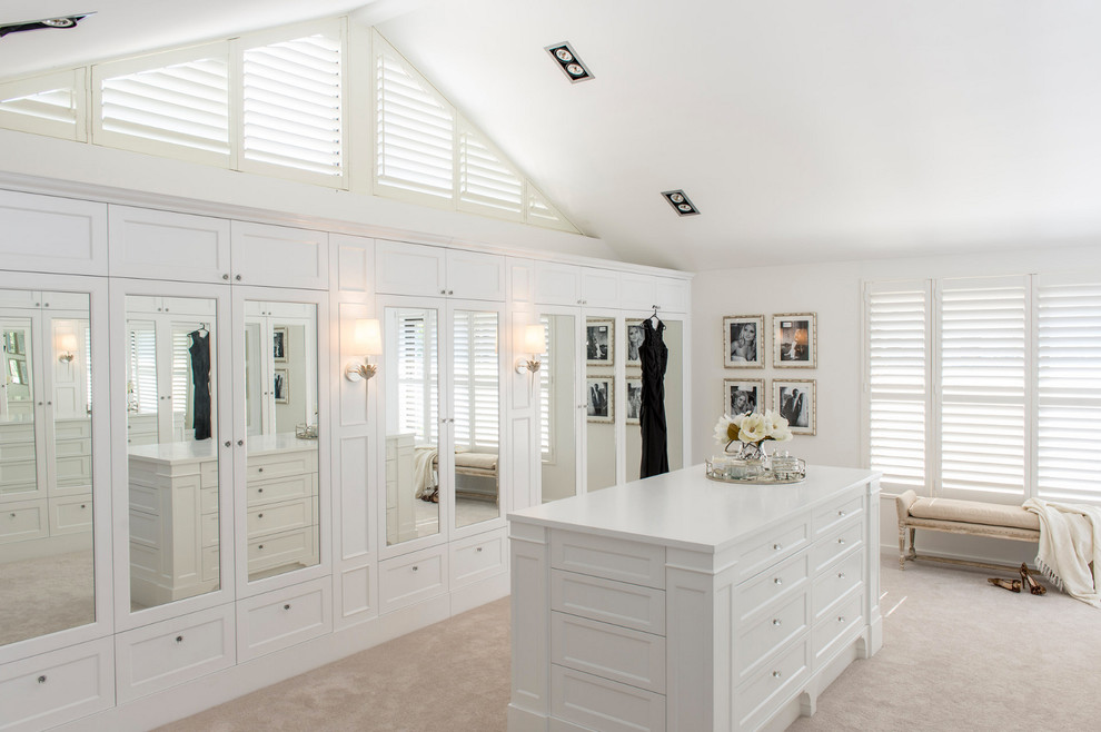 Photo of an expansive beach style gender-neutral dressing room in Brisbane with white cabinets and carpet.