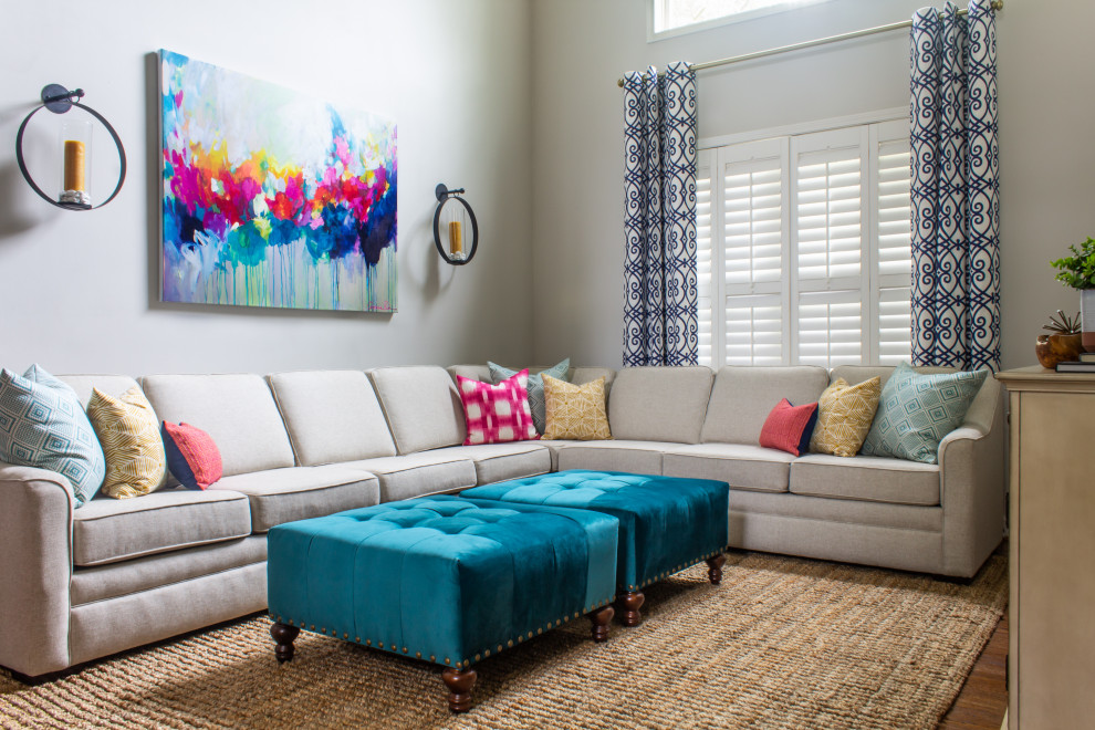Ejemplo de sala de estar abierta clásica renovada grande con paredes grises, suelo de madera en tonos medios y televisor colgado en la pared