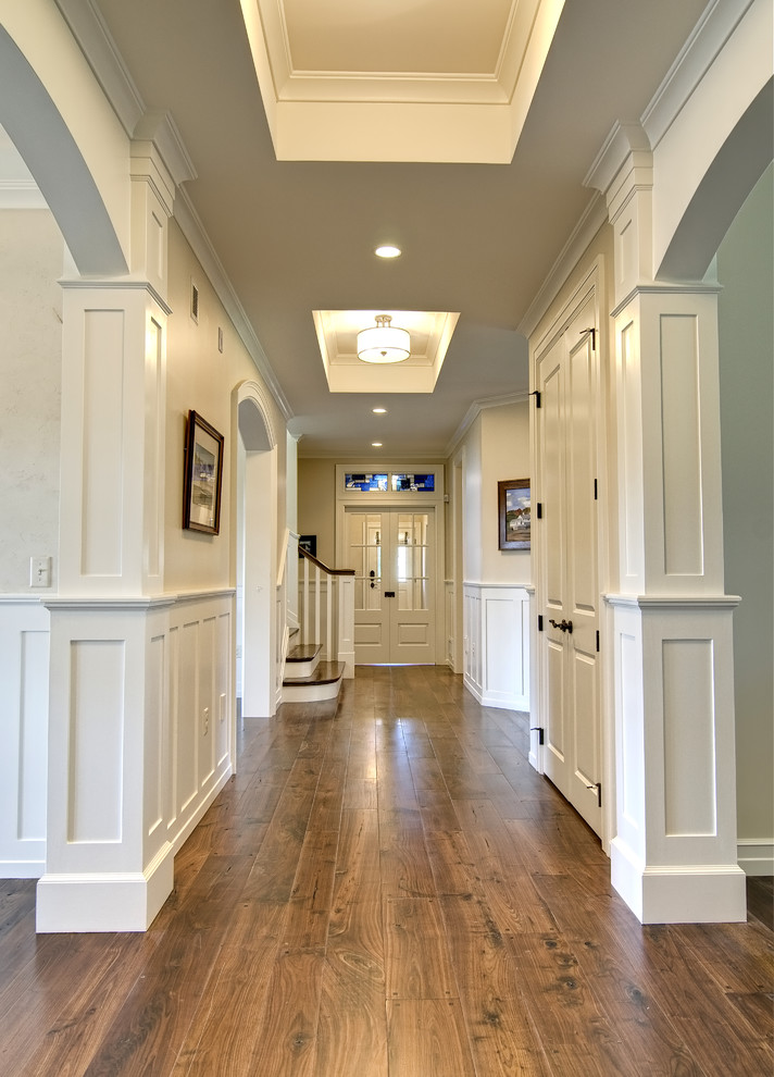 Photo of a traditional hallway in Other with beige walls, medium hardwood floors and brown floor.