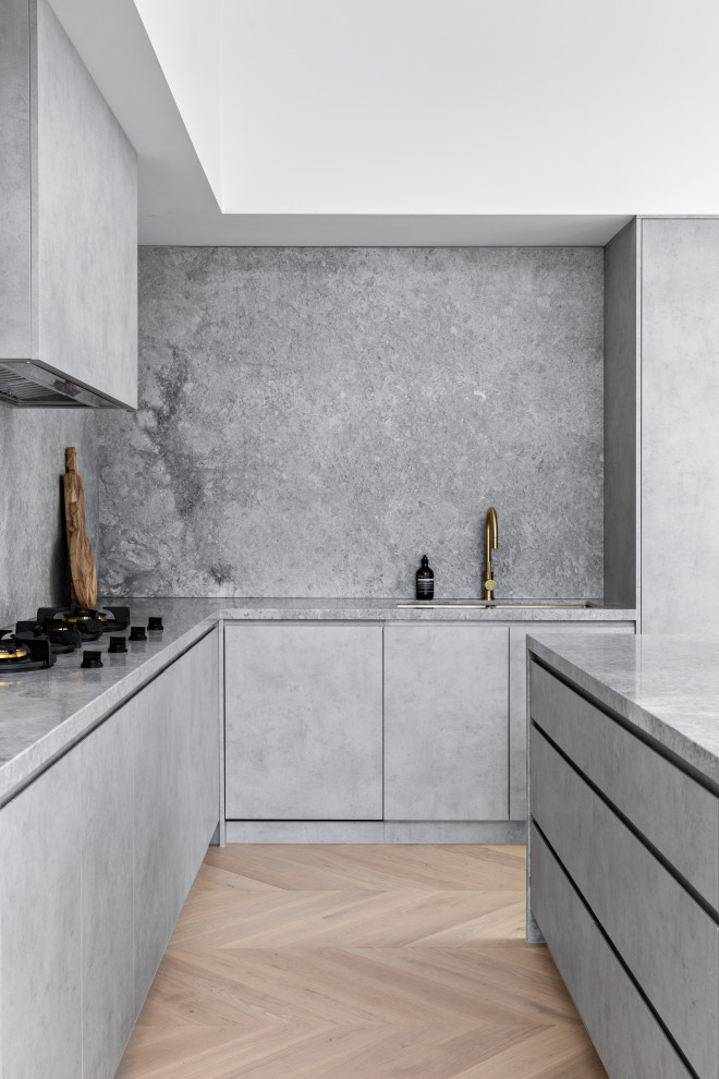 This is an example of a large mediterranean l-shaped separate kitchen in Sydney with an undermount sink, grey cabinets, marble benchtops, grey splashback, marble splashback, black appliances, with island and grey benchtop.
