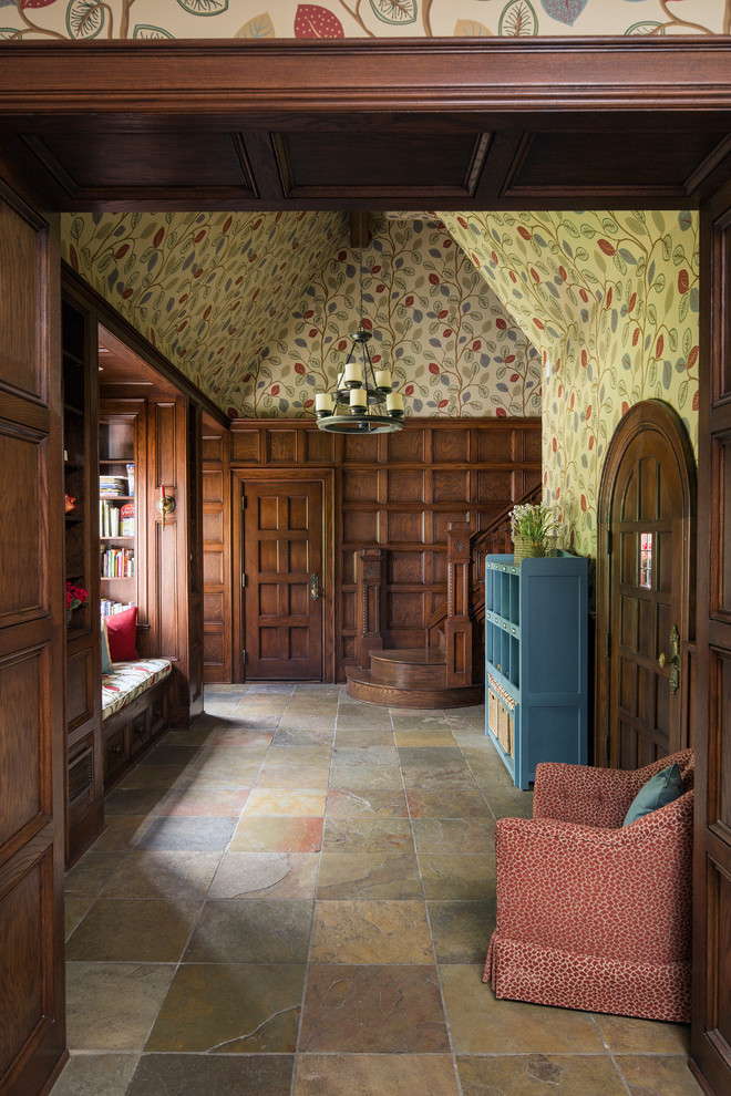 Large traditional entry hall in Indianapolis with multi-coloured walls, slate floors, a single front door and a dark wood front door.