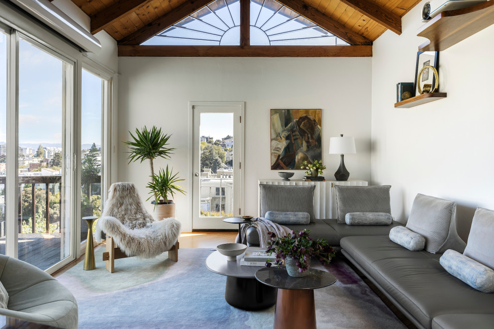 Inspiration for a mid-sized contemporary enclosed light wood floor and vaulted ceiling living room remodel in San Francisco with white walls, no fireplace and a wall-mounted tv