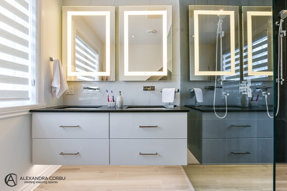 This is an example of a large contemporary master bathroom in Montreal with a freestanding tub, a double shower, a wall-mount toilet, white tile, ceramic tile, multi-coloured walls, ceramic floors and quartzite benchtops.