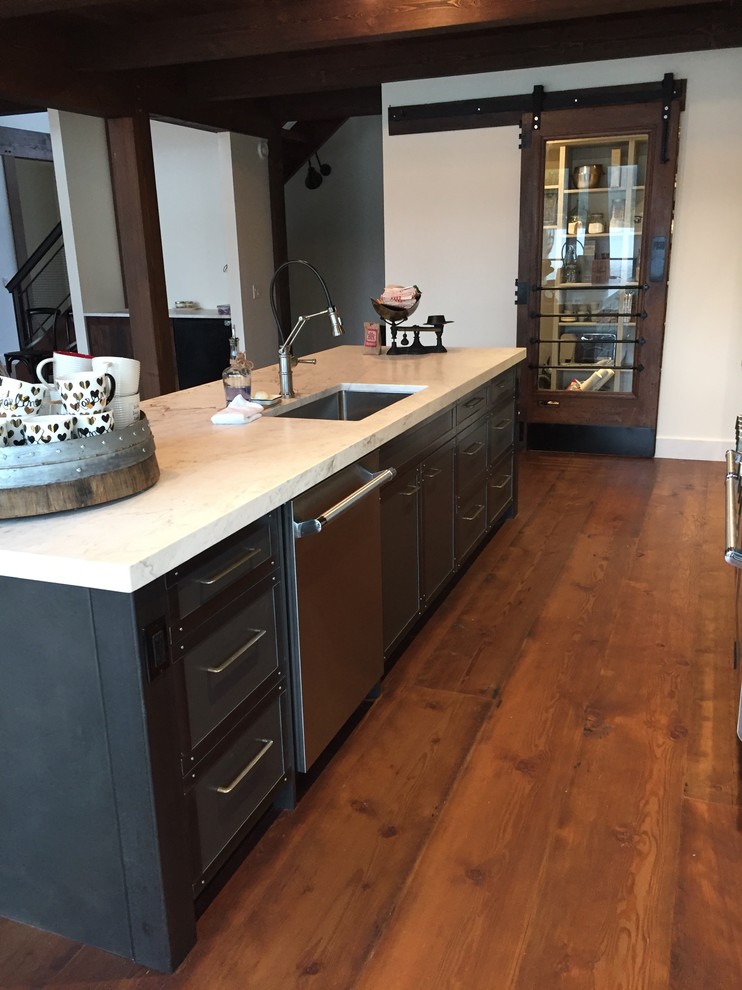 Open concept kitchen - large rustic galley medium tone wood floor open concept kitchen idea with an undermount sink, recessed-panel cabinets, gray cabinets, granite countertops, white backsplash, ceramic backsplash, stainless steel appliances and an island
