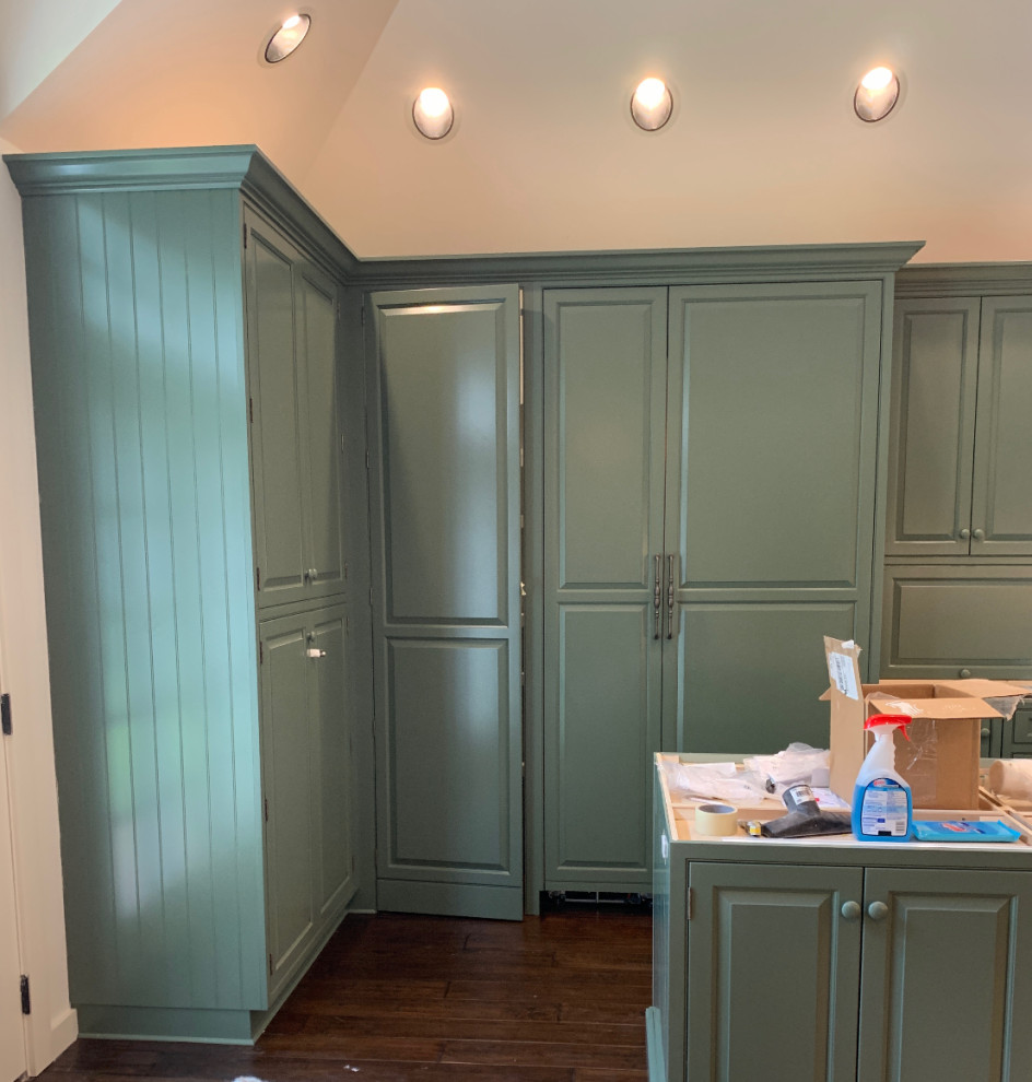 Inspiration for a transitional u-shaped kitchen remodel with a farmhouse sink, raised-panel cabinets, green cabinets, soapstone countertops, stainless steel appliances and an island
