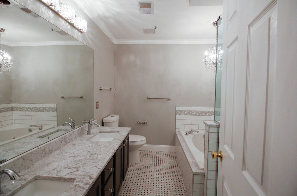 Photo of a mid-sized traditional master bathroom in New York with flat-panel cabinets, grey cabinets, a drop-in tub, a corner shower, an urinal, white tile, ceramic tile, grey walls, mosaic tile floors, an undermount sink, marble benchtops, white floor and a hinged shower door.