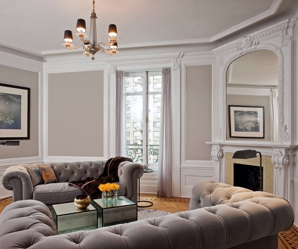 This is an example of a traditional formal enclosed living room in New York with grey walls, light hardwood floors, a standard fireplace and no tv.