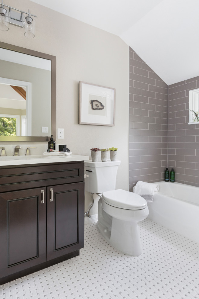 Small transitional kids bathroom in Denver with raised-panel cabinets, dark wood cabinets, an alcove tub, a shower/bathtub combo, a two-piece toilet, gray tile, ceramic tile, grey walls, mosaic tile floors, an undermount sink, engineered quartz benchtops, white floor, a shower curtain and white benchtops.