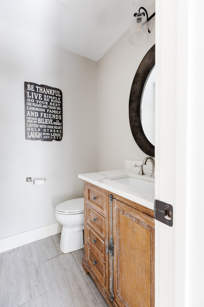 Réalisation d'un petit WC et toilettes chalet en bois vieilli avec un placard en trompe-l'oeil, WC séparés, un mur gris, un lavabo encastré, un plan de toilette en quartz modifié, un sol gris, un plan de toilette blanc et meuble-lavabo encastré.