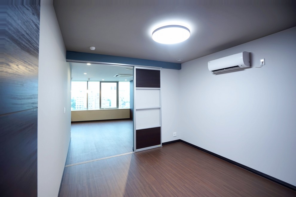 Immagine di una cameretta per bambini minimalista di medie dimensioni con pareti bianche, pavimento in compensato, pavimento marrone, soffitto in carta da parati e carta da parati