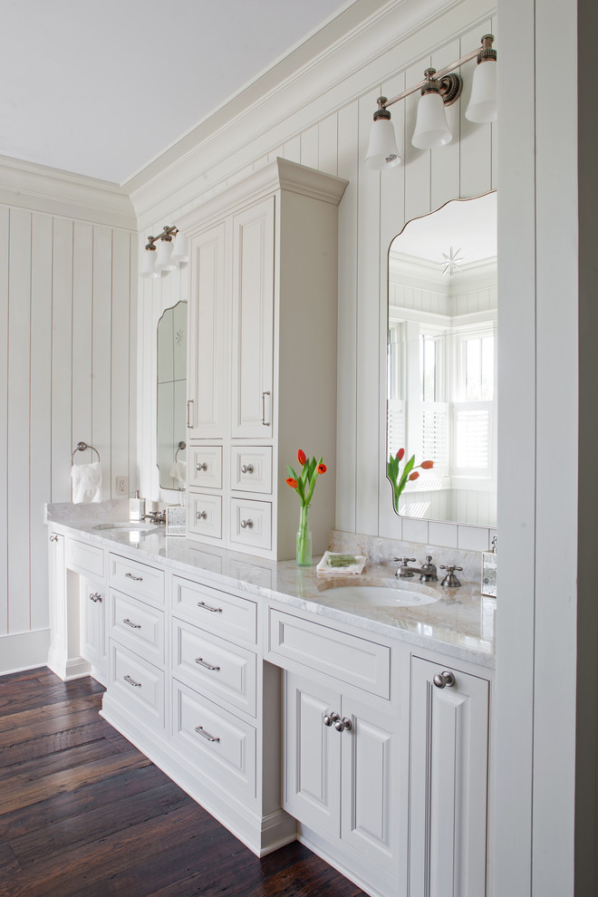 Design ideas for a country bathroom in Atlanta with raised-panel cabinets, white cabinets, white walls, dark hardwood floors, an undermount sink and brown floor.