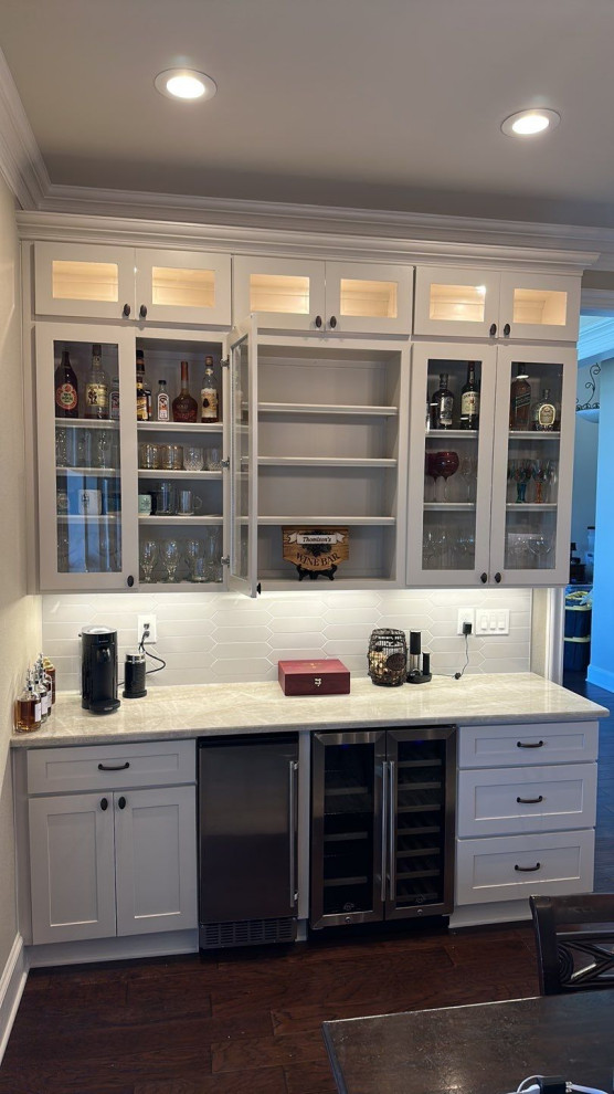 Inspiration for a small transitional single-wall home bar in Dallas with no sink, shaker cabinets, beige cabinets, quartzite benchtops, grey splashback, ceramic splashback, brown floor and beige benchtop.