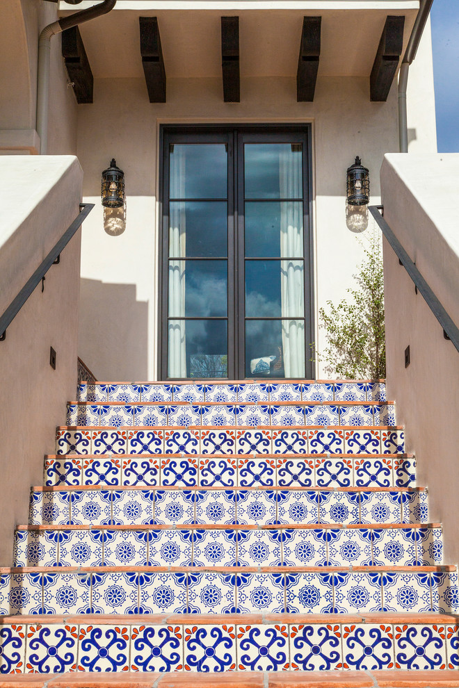 Design ideas for a mediterranean terracotta staircase in Los Angeles with tile risers and metal railing.