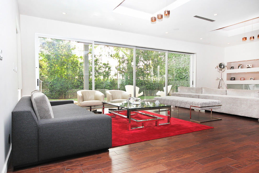 This is an example of a large contemporary open concept living room in Los Angeles with medium hardwood floors and a wall-mounted tv.