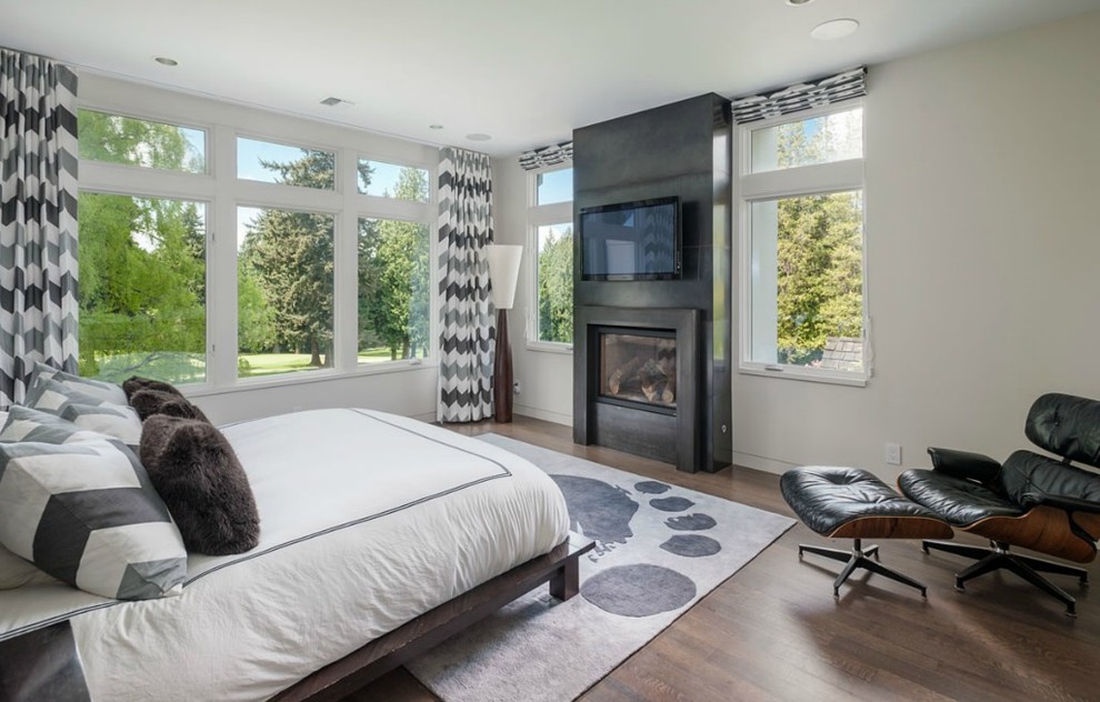 Inspiration for a mid-sized contemporary master bedroom in Seattle with white walls, dark hardwood floors, a standard fireplace and a concrete fireplace surround.
