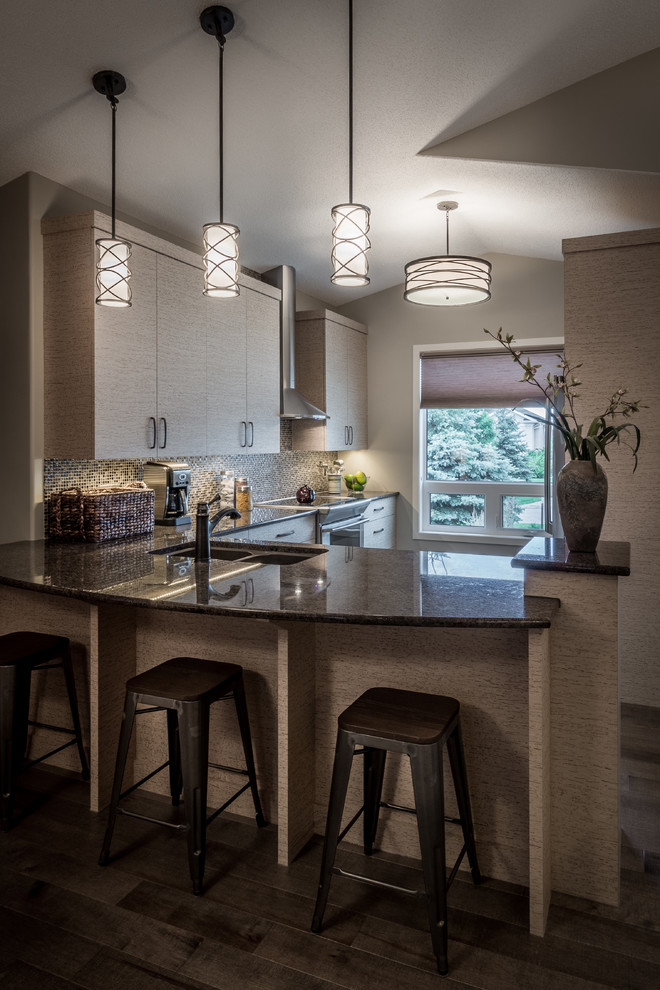 Enclosed kitchen - mid-sized modern u-shaped medium tone wood floor and gray floor enclosed kitchen idea with a double-bowl sink, flat-panel cabinets, beige cabinets, granite countertops, multicolored backsplash, mosaic tile backsplash, stainless steel appliances and a peninsula