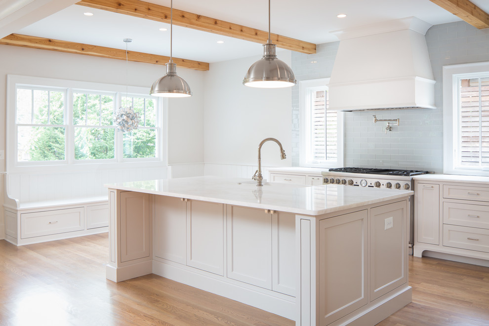 Traditional u-shaped kitchen in Atlanta with an undermount sink, recessed-panel cabinets, white cabinets, blue splashback, glass tile splashback, stainless steel appliances, medium hardwood floors and with island.