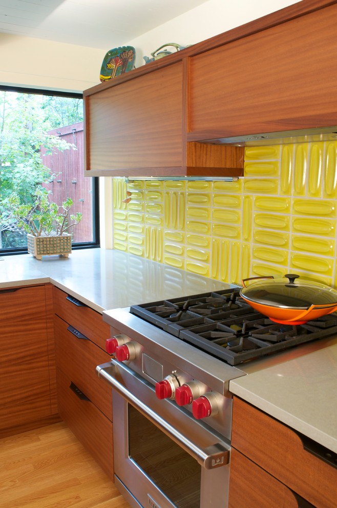 Mid-sized midcentury u-shaped kitchen pantry in Denver with a double-bowl sink, flat-panel cabinets, medium wood cabinets, quartz benchtops, yellow splashback, stainless steel appliances and light hardwood floors.