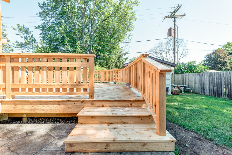 Example of a large transitional backyard deck design in Chicago with a pergola