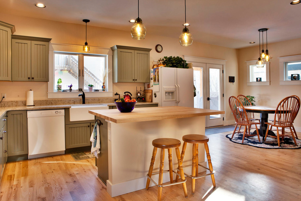 This is an example of a mid-sized arts and crafts l-shaped kitchen in Other with a farmhouse sink, shaker cabinets, green cabinets, white appliances, medium hardwood floors, with island, brown floor and beige benchtop.