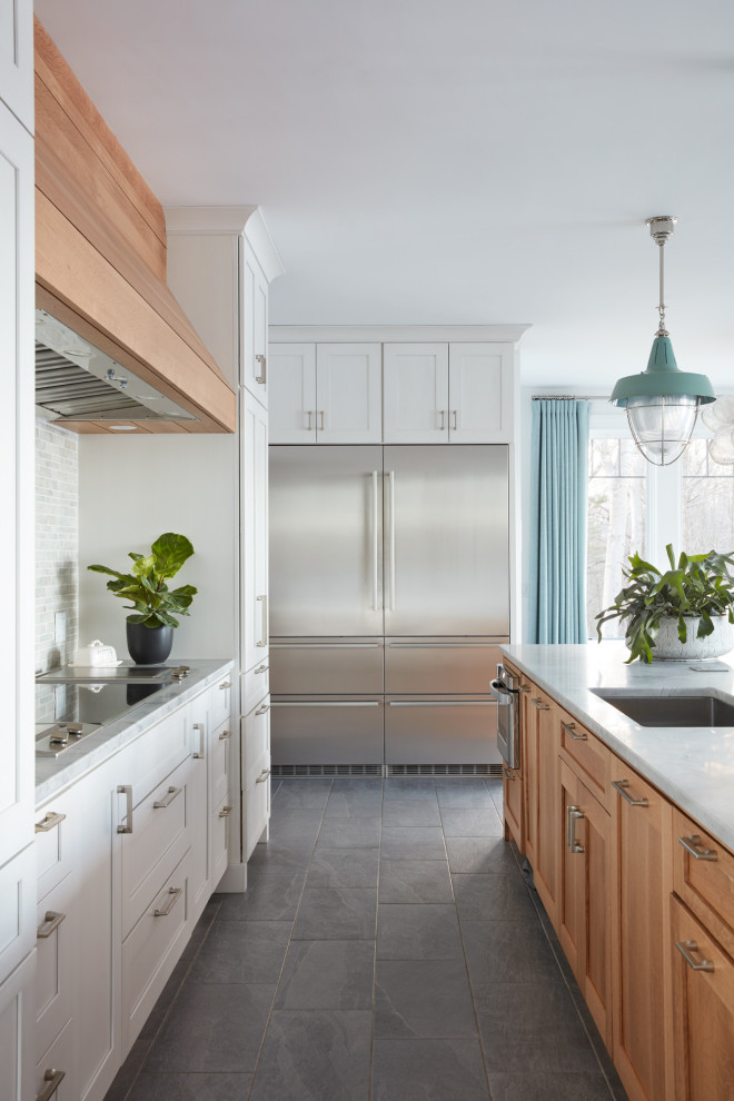 This is an example of an expansive traditional grey and teal galley open plan kitchen in Boston with white cabinets, quartz worktops, white splashback, stainless steel appliances, an island, grey floors, grey worktops and ceramic flooring.