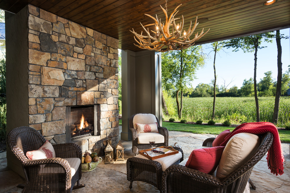 Design ideas for a country patio in Minneapolis with natural stone pavers and with fireplace.