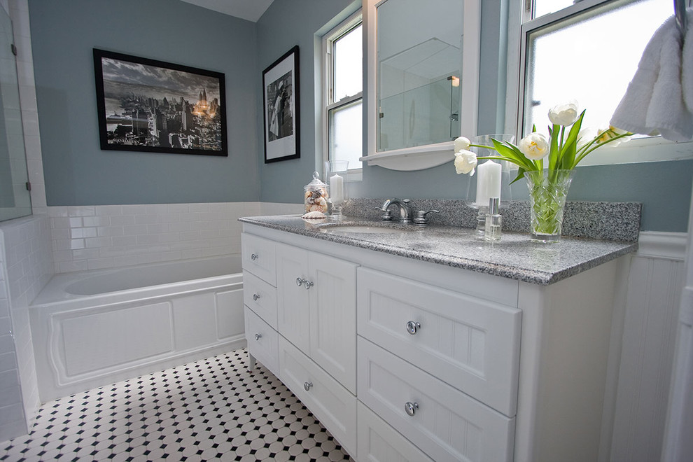 This is an example of a mid-sized traditional bathroom in Los Angeles with an undermount sink, beaded inset cabinets, white cabinets, granite benchtops, an alcove tub, white tile, subway tile, blue walls and mosaic tile floors.