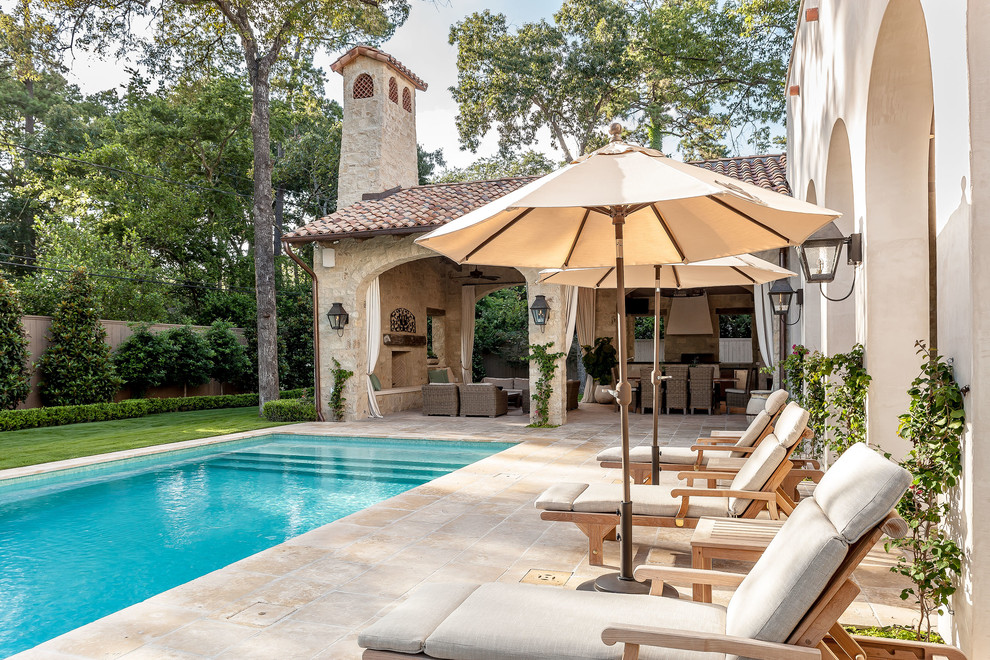 Photo of a mid-sized mediterranean backyard rectangular lap pool in Houston with natural stone pavers.